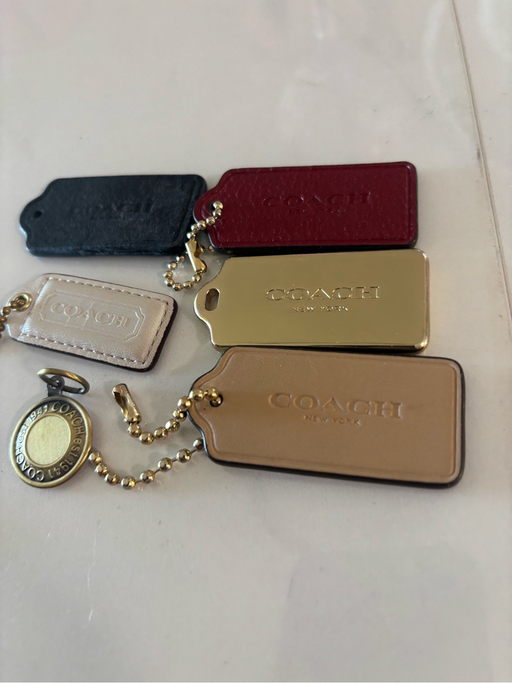 Coach Leather and Metal Tag Set in Black, Burgundy, Cream, Tan & Gold
